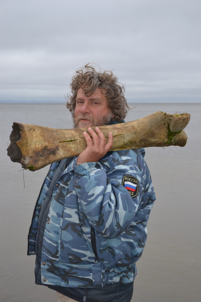 Участник экспедиции Вадим Рябиков со случайно найденной в ленской мерзлоте костью мамонта. 